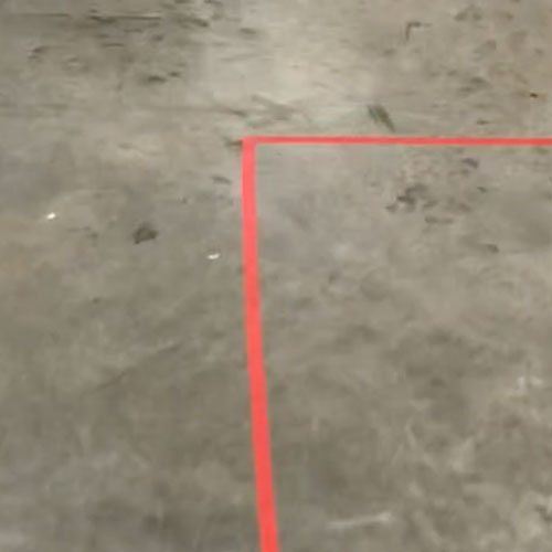 A red line taped on the floor going around a corner